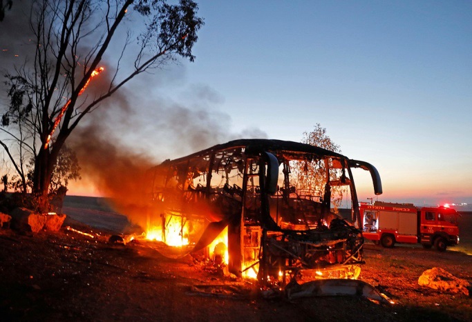 A bus in flames after it was hit by a Kornet anti tank missile